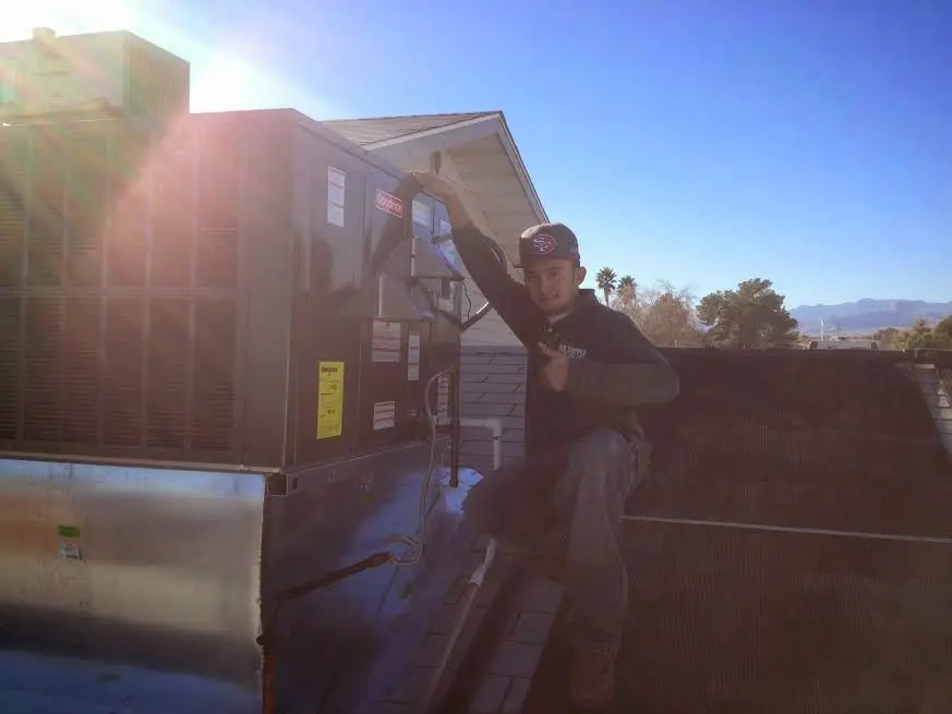HVAC technician performing Heat Pump Repair on a rooftop unit in Carrollton